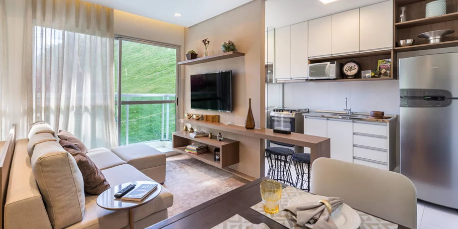 SALA do apto de 50 m² integrada à cozinha americana, tornando o ambiente mais fluido, facilitando a circulação e conectando visualmente os espaços.