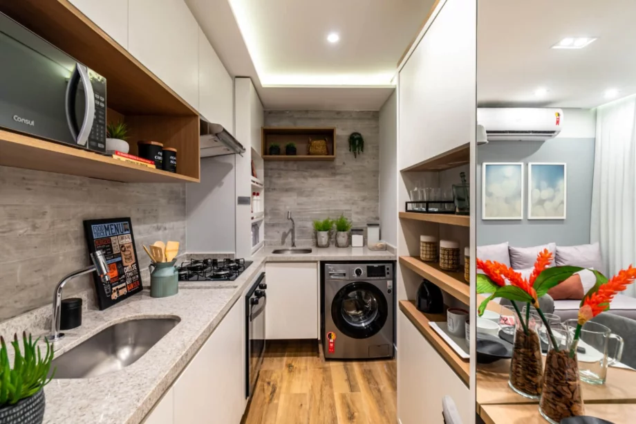 COZINHA do apto de 34 m² que faz conexão com a área de serviço, criando fluidez no espaço de trabalhos domésticos.